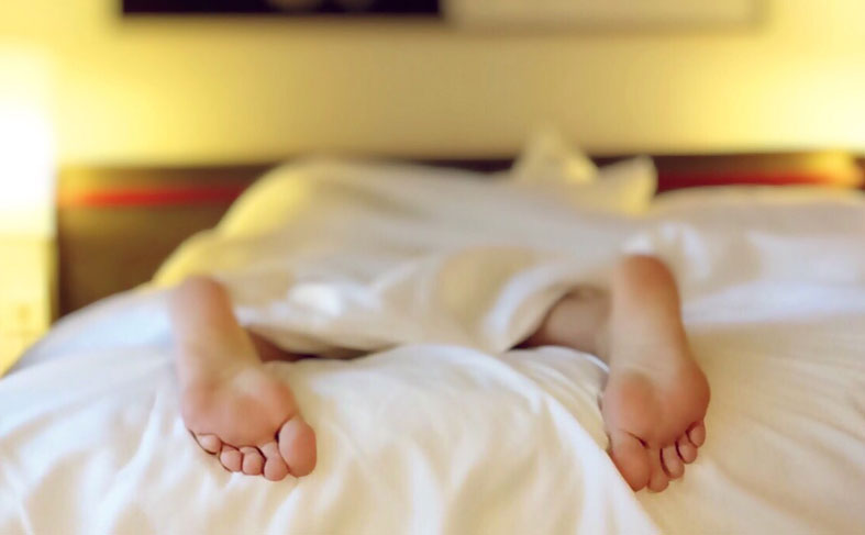 lying in bed with uncovered feet