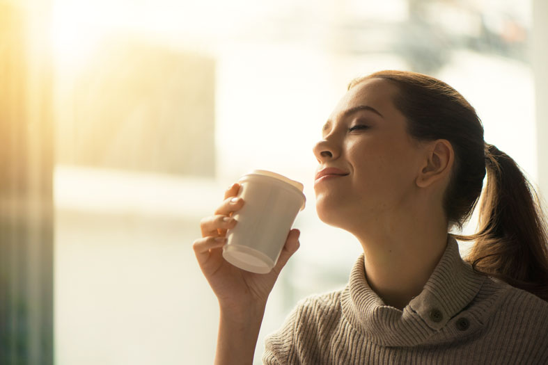 happy woman drinking her morning coffee