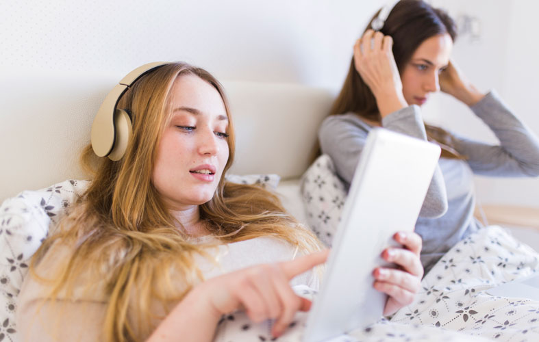 girls in bed listen music