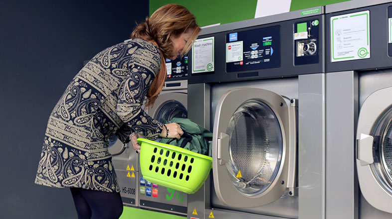 Woman-is-putting-stuff-in-the-washing-machine Woman is putting stuff in the washing machine