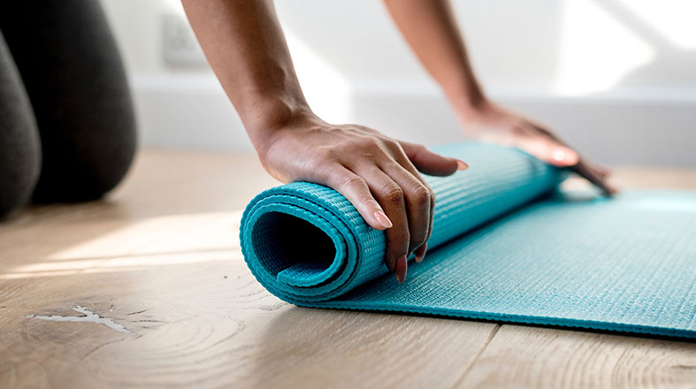 female hands are rolling in the mat for yoga