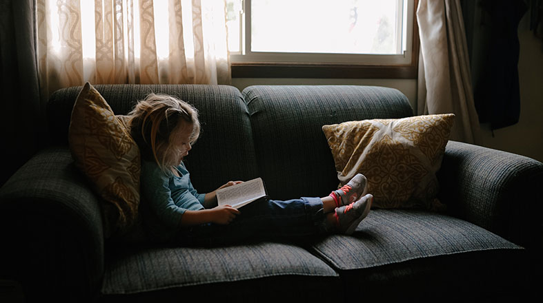 little-girl-is-reading-on-the-sofa little girl is reading on the sofa
