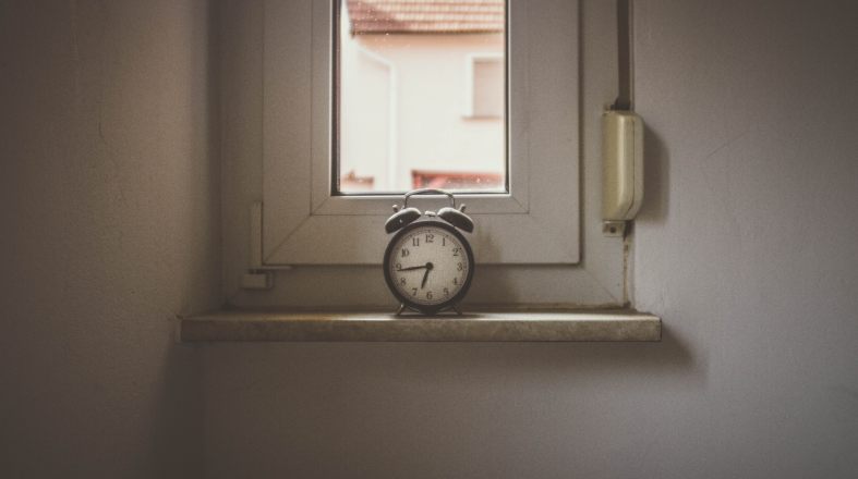 old clock is standing on the window from the inside