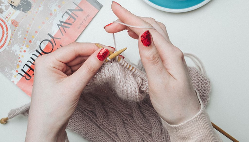 Woman's hands are knitting the clothes