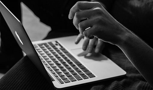 Black and white photo of a man holding a laptop