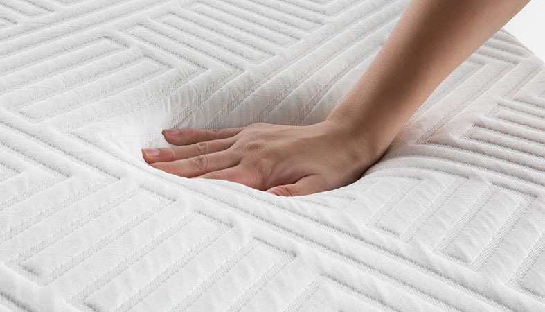 close-up photo of hand pressing the innerspring mattress