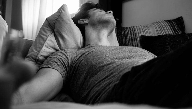 man-sleeps-on-a-couch man sleeps on a couch