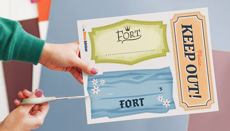 How to Build the Ultimate Pillow Fort + Printable Fort Kit 3 person cutting signs