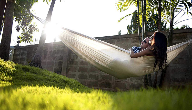 a couple is laying in the hammock