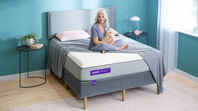 Image of a Woman Sitting on Purple Hybrid Premier 3 Bed Image of a Woman Sitting on Purple Hybrid Premier 3 Bed