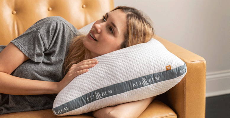 the woman is lying on the eli & elm side sleeper pillow