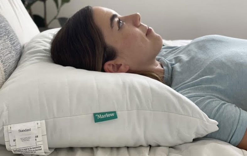 a-woman-lays-on-brooklinen-marlow-pillow a woman lays on brooklinen marlow pillow