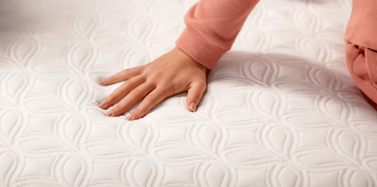 woman squeezing a cocoon chill hybrid mattress