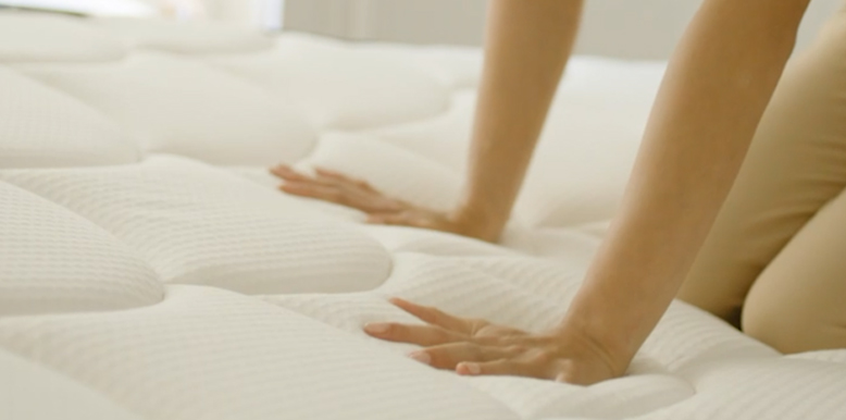 a person is pushing the dreamcloud premier rest mattress with her hands