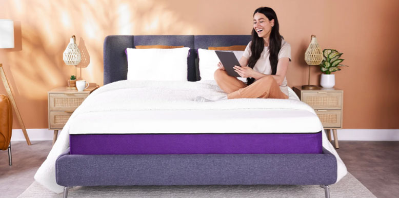 a happy lady is sitting on her polysleep mattress