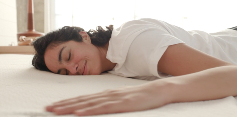 a-woman-is-lying-on-her-stomach-on-an-avocado-eco-organic-mattress a woman is lying on her stomach on an avocado eco organic mattress