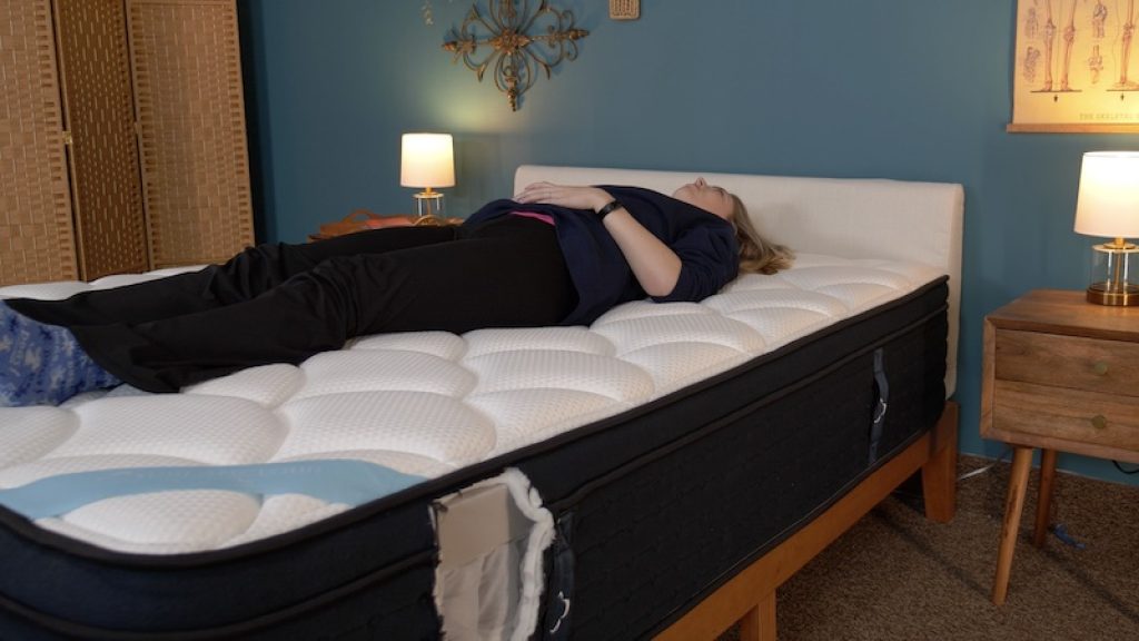 Julia Forbes testing a mattress in the back sleeper sleeping position