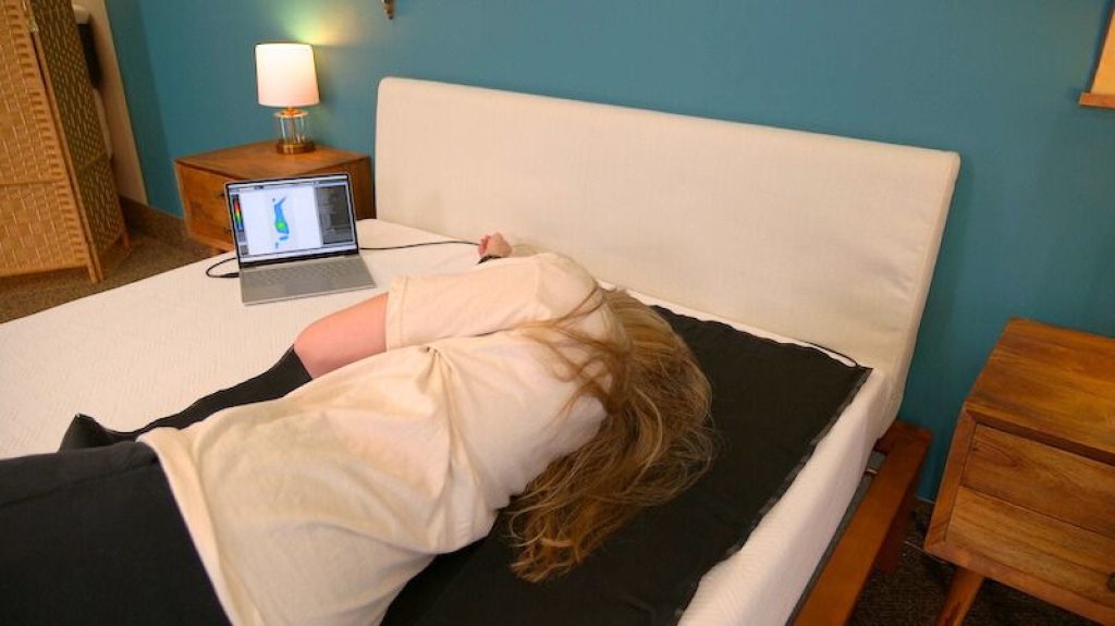 Julia Forbes testing a mattress for pressure relief