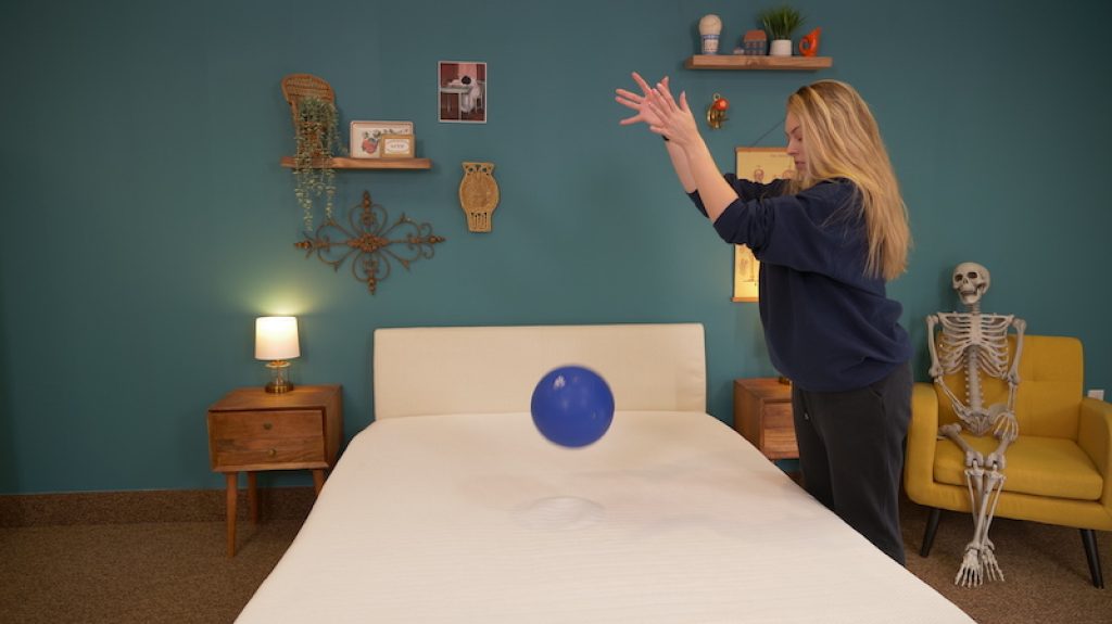 Julia Forbes testing a mattress's bounce
