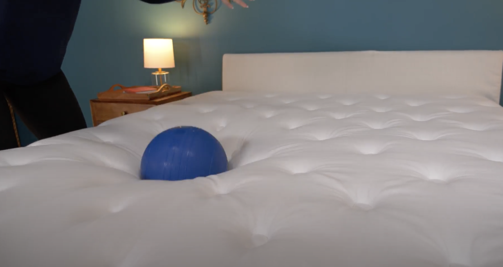 Our testers testing responsiveness of the Winkbed mattress with a weighted ball drop test.